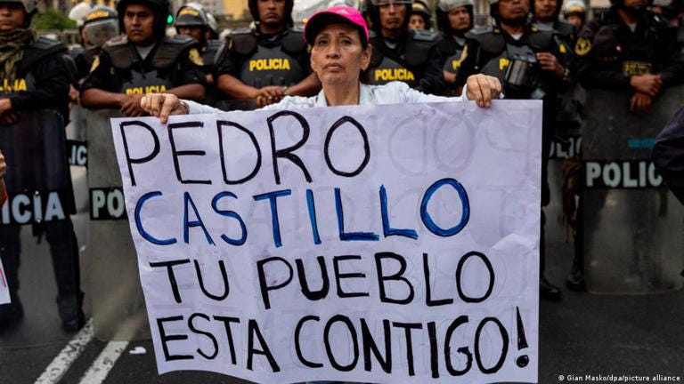A woman holds a placard reading 'Pedro Castillo, the people are with you' during a demonstration calling for his release