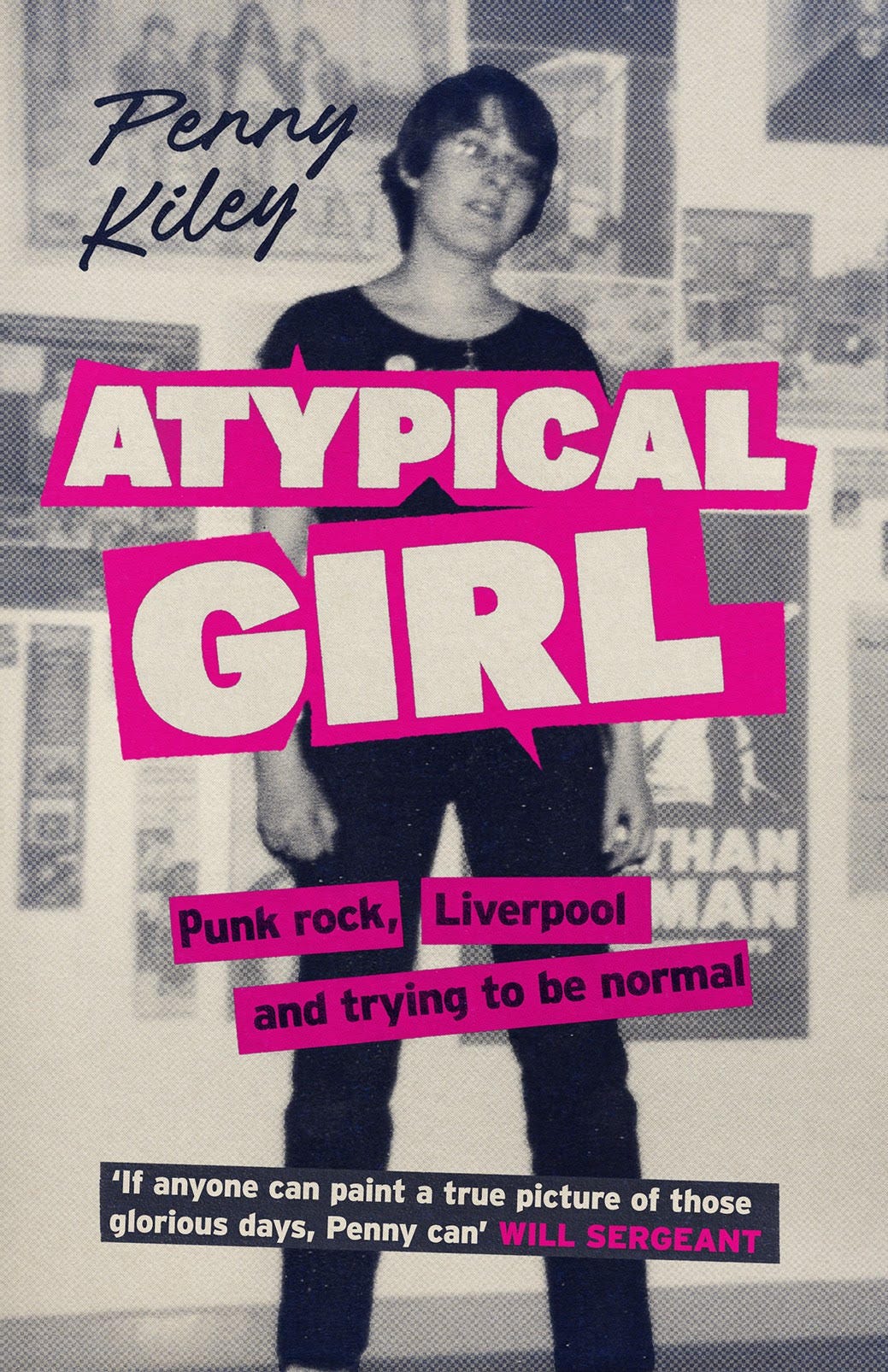 The cover of Atypical Girl. It shows a young punk woman posing in front of a wall of posters. The picture is black and white and the book title is in pink.