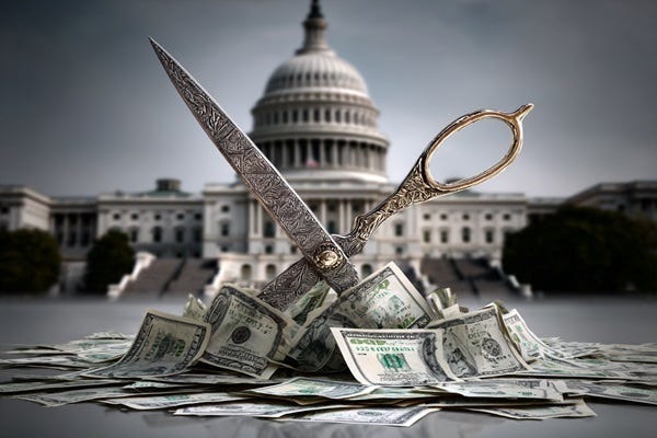 Scissors cutting dollar bills in front of the Capitol.