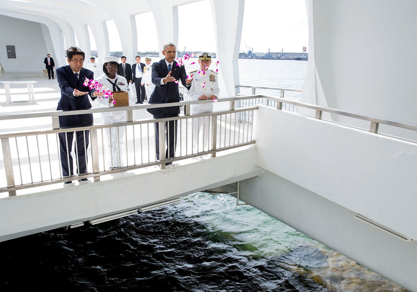 December 27, 2016: President Obama and Prime Minister Shinzo Abe of Japan toss flowers into a wishing well after laying a wreath at the USS Arizona Memorial in Pearl Harbor, a poignant gesture of peace. December 27, 2016: President Obama and Prime Minister Shinzo Abe of Japan toss flowers into a wishing well after laying a wreath at the USS Arizona Memorial in Pearl Harbor, a poignant gesture of peace.