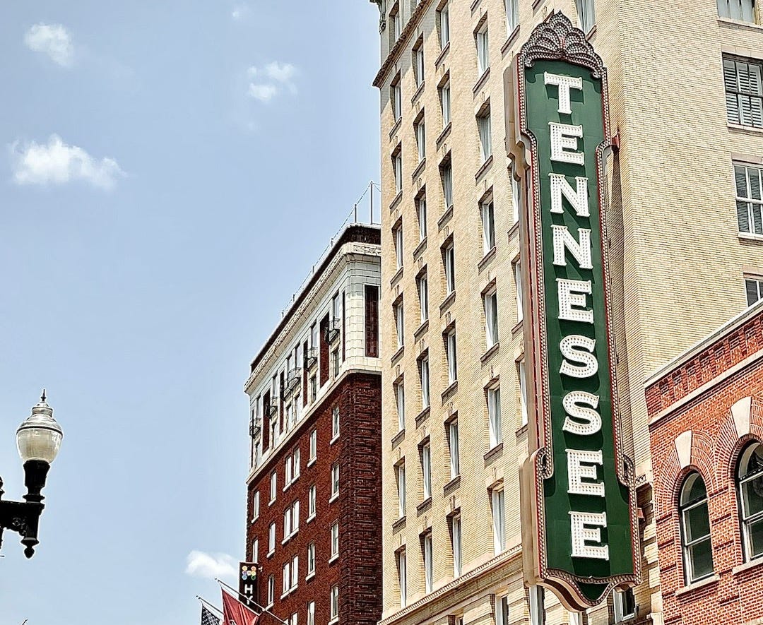 brown concrete building with green and white signage