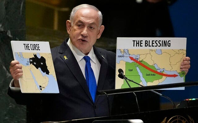 Prime Minister Benjamin Netanyahu hold signs as he addresses the 79th session of the UN General Assembly, September 27, 2024. (AP Photo/Pamela Smith)