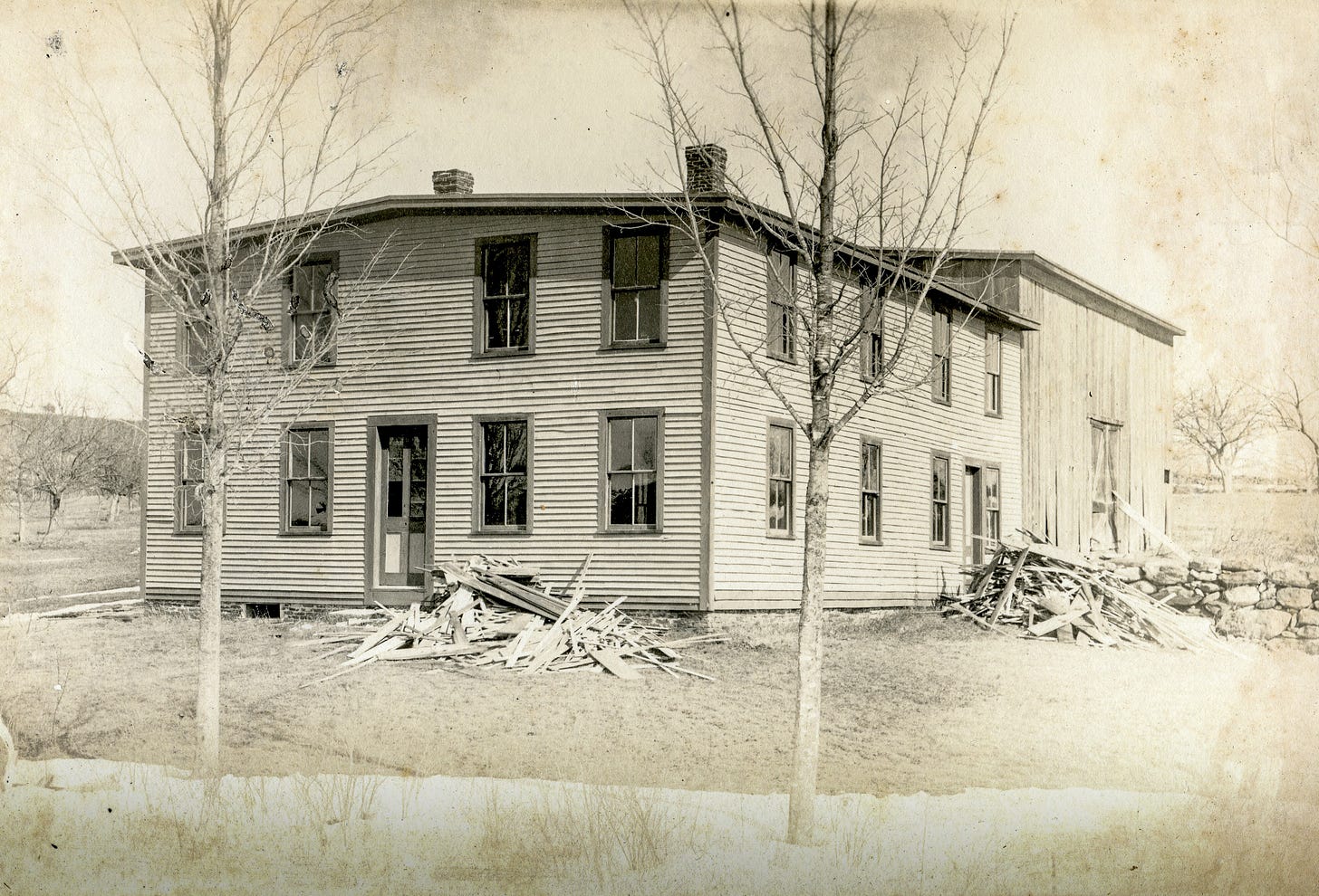 House with barn and piles of wood