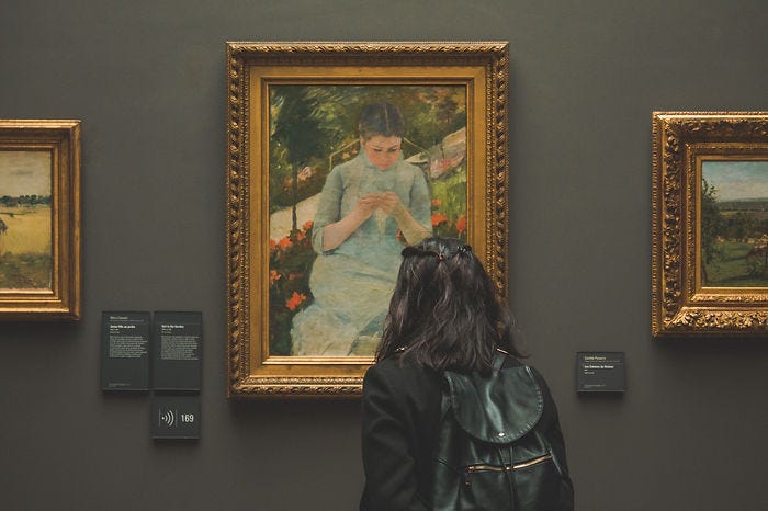 Woman looking at painting in a museum