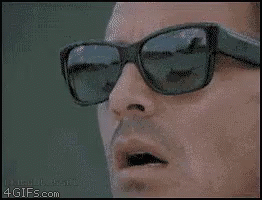 a man wearing sunglasses is smoking a cigarette ..