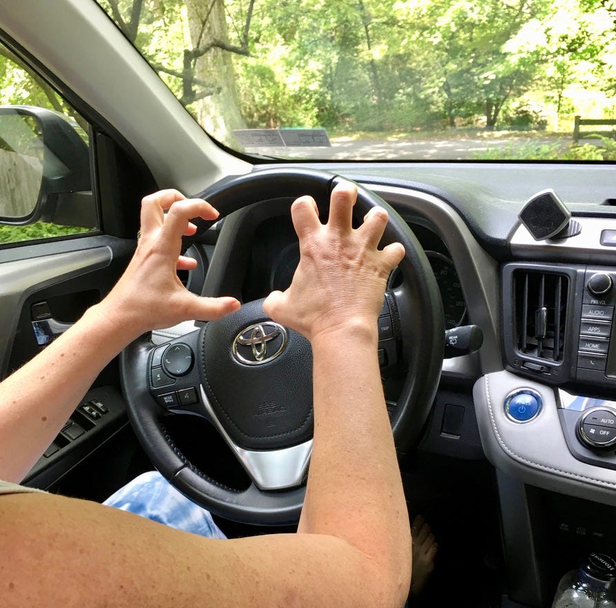A person driving a car with hands on the steering wheel

AI-generated content may be incorrect.