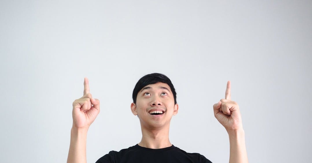 a man holding two fingers up in the air