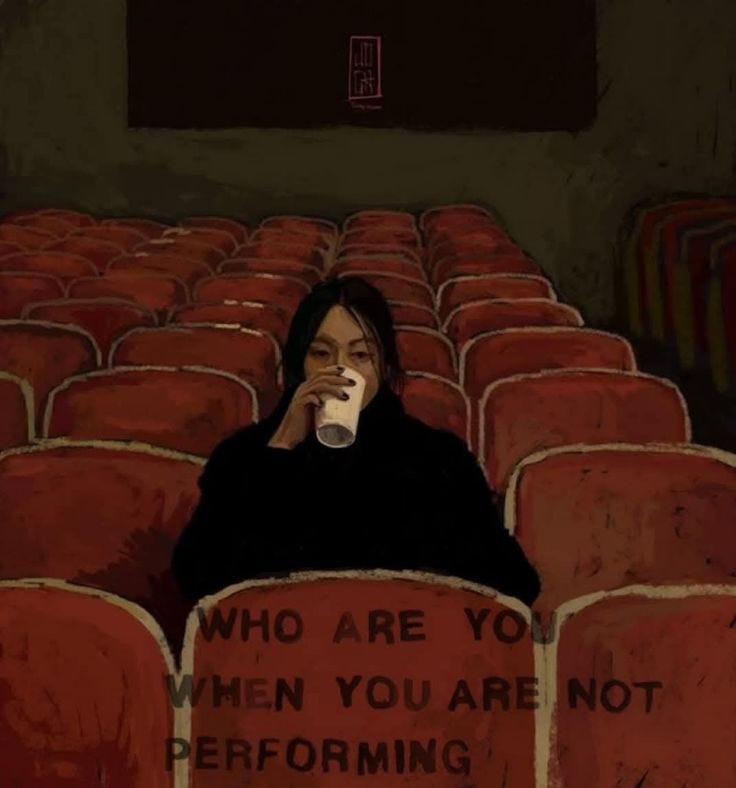 This may contain: a woman sitting in an empty theater holding a cup