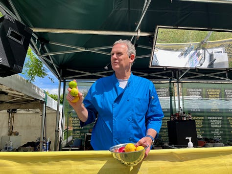 Three images of a man dressed in a blue shirt at a food festival standing on a stage squeezing a lemon
