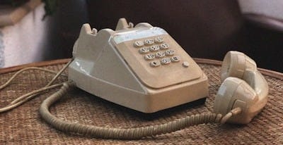 white and gray ip desk phone on brown wooden table