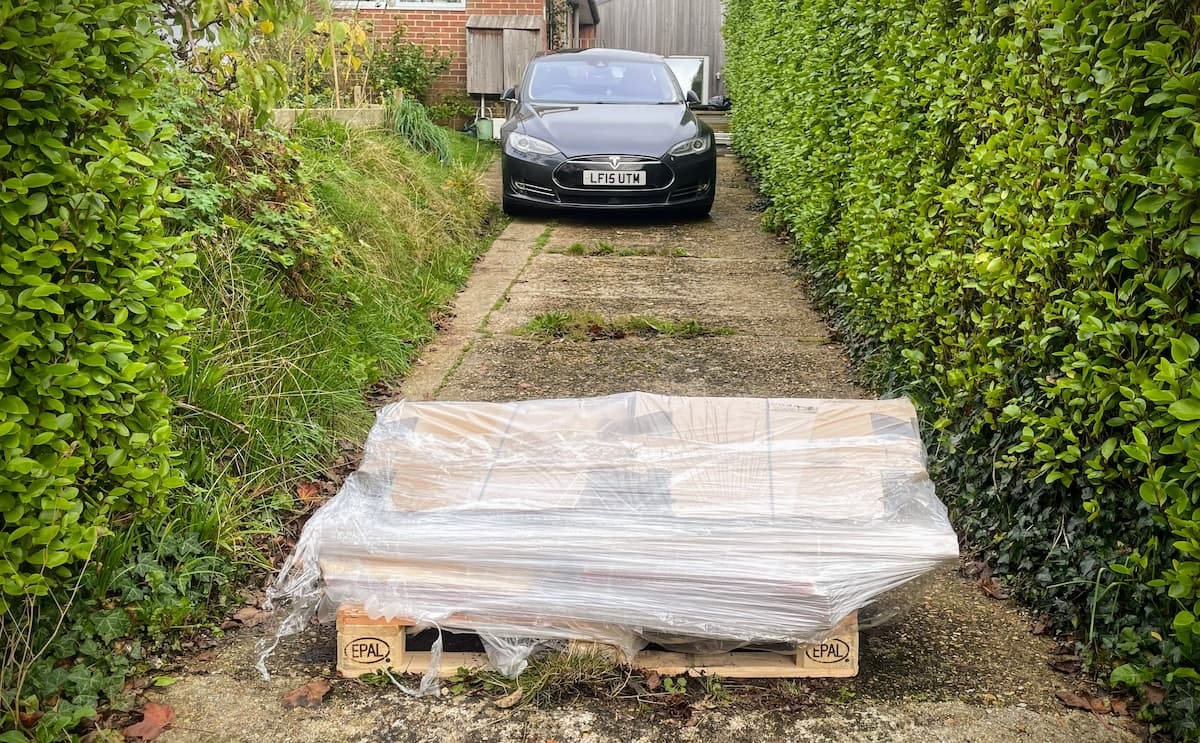 The pallet of packaging sitting on Tom's driveway with a car and house in the background