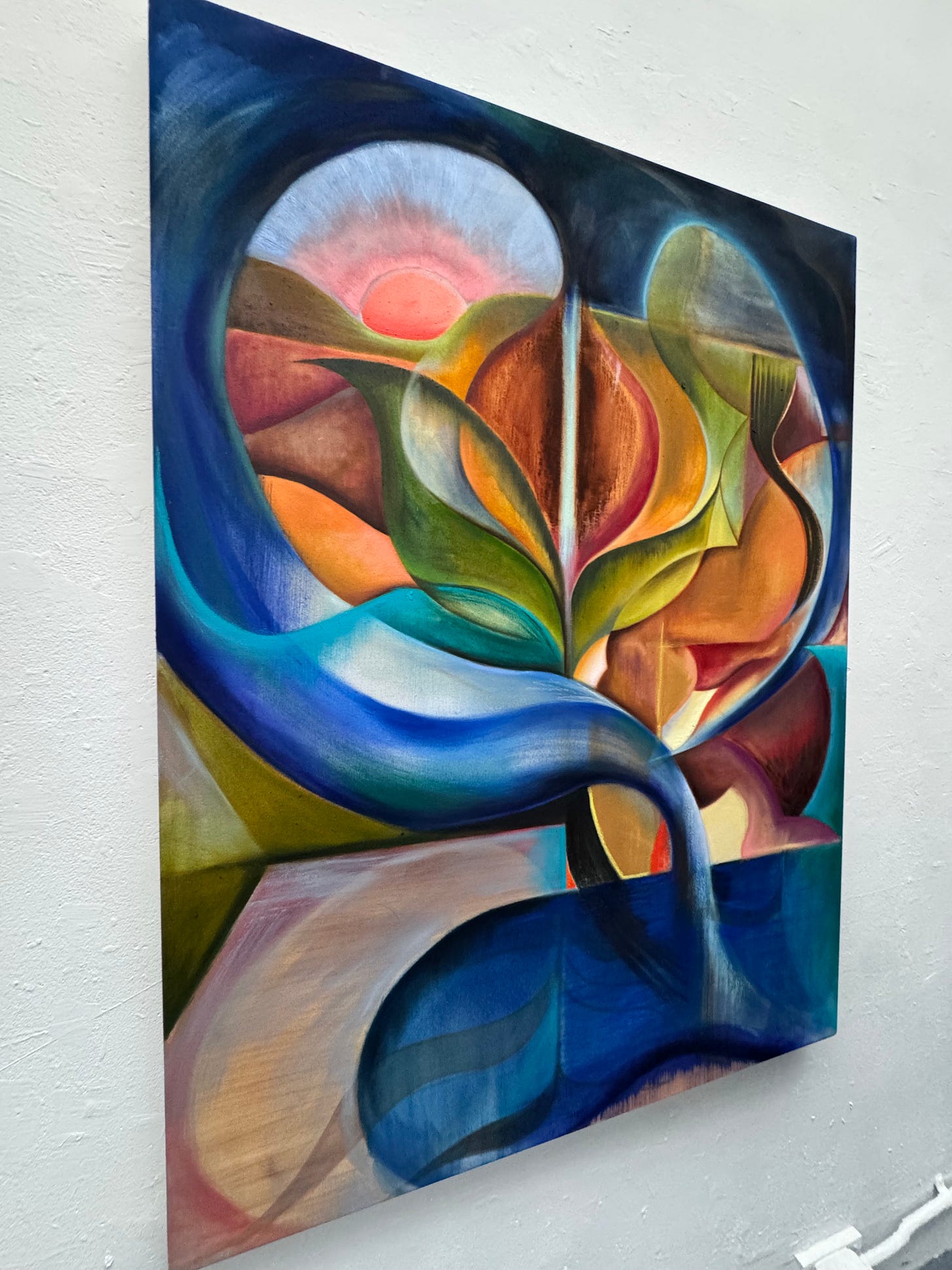 Alex Maceda’s painting my empty womb is full of paintings, shown at an angle on a white wall, with layered blue, green, orange, and pink forms. Alex Maceda’s painting my empty womb is full of paintings, shown at an angle on a white wall, with layered blue, green, orange, and pink forms.