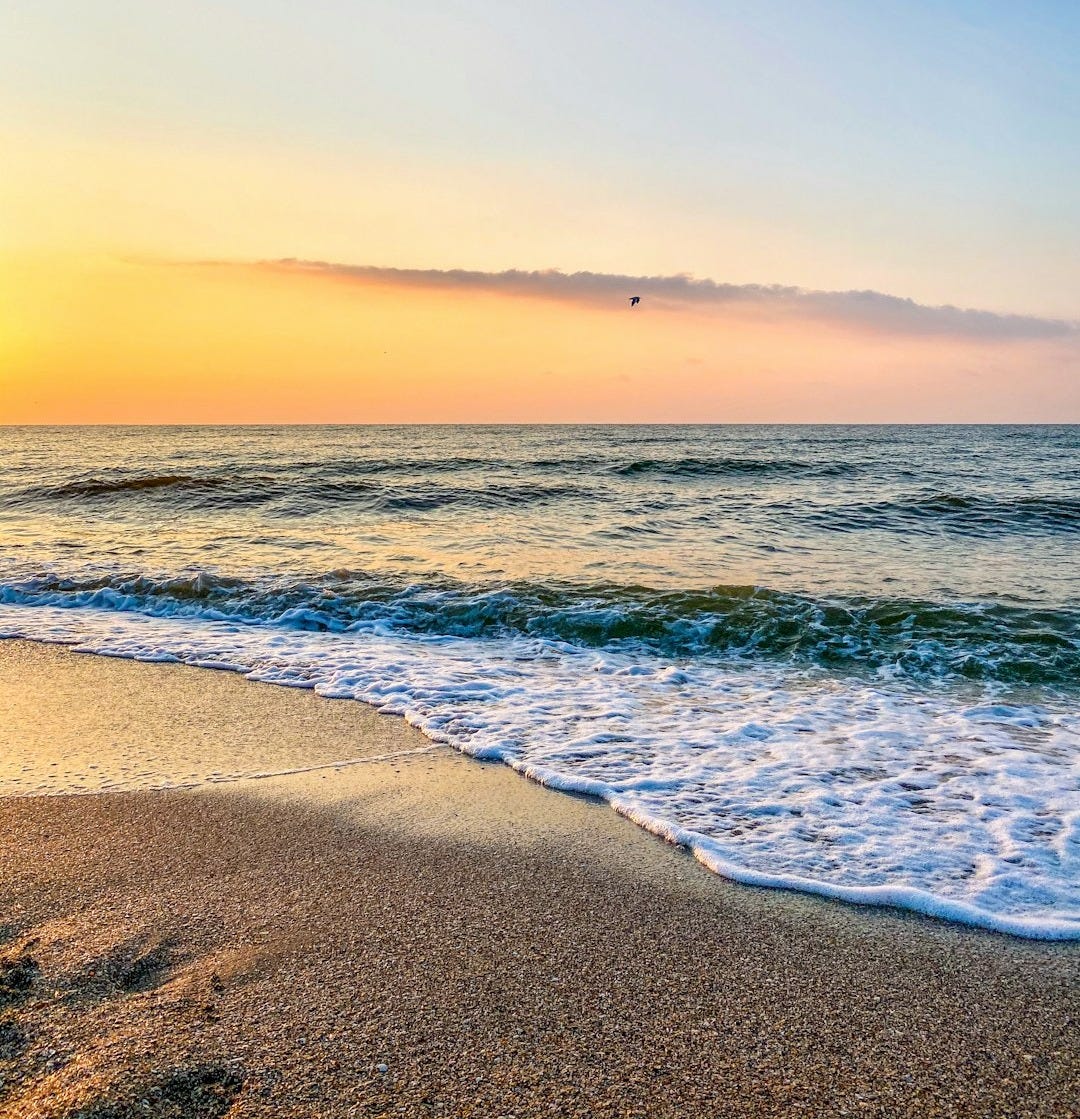 ocean waves crashing on shore during sunset