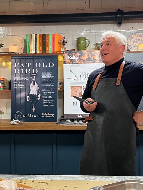 Paul Kelly of the Kelly Bronze company, standing behind a counter demonstrating carving technique.