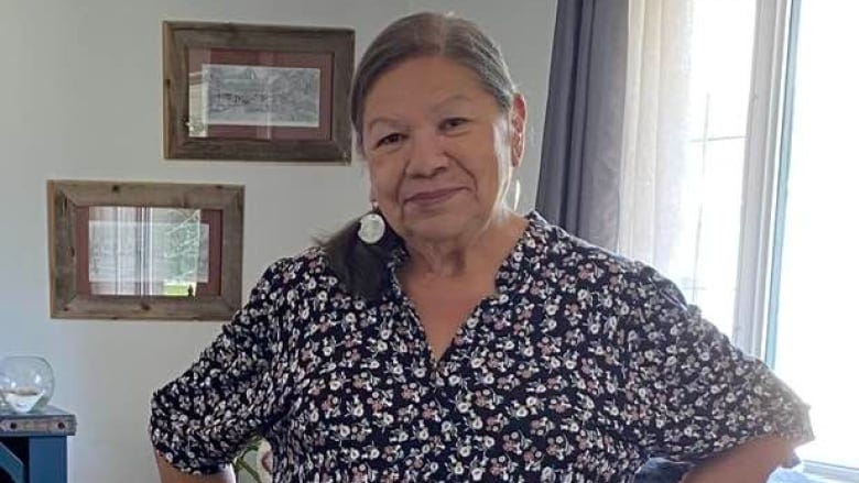 An Indigenous woman in a floral dress 