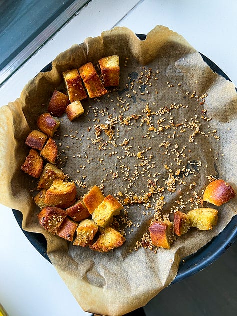 Voorbereiding: "Stukjes brood gemengd met gekruide olijfolie, verspreid op een bakplaat klaar om te bakken."  Tijdens het bakken: "Croutons die goudbruin worden in de oven op een bakplaat."  Eindresultaat: "Goudbruine, knapperige croutons in een schaal, klaar om te serveren."  Met een salade: "Frisse groene salade gegarneerd met zelfgemaakte knapperige croutons."  Close-up: "Close-up van perfect goudbruine en kruidige croutons met een knapperige textuur."