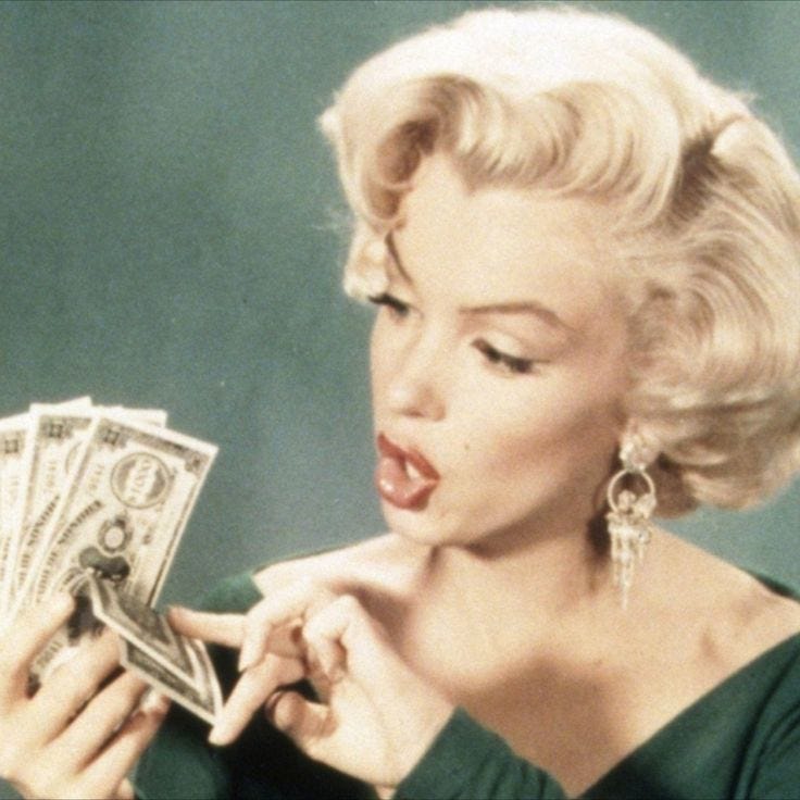 This may contain: marilyn monroe holding money in her hand and making a face with it's mouth open