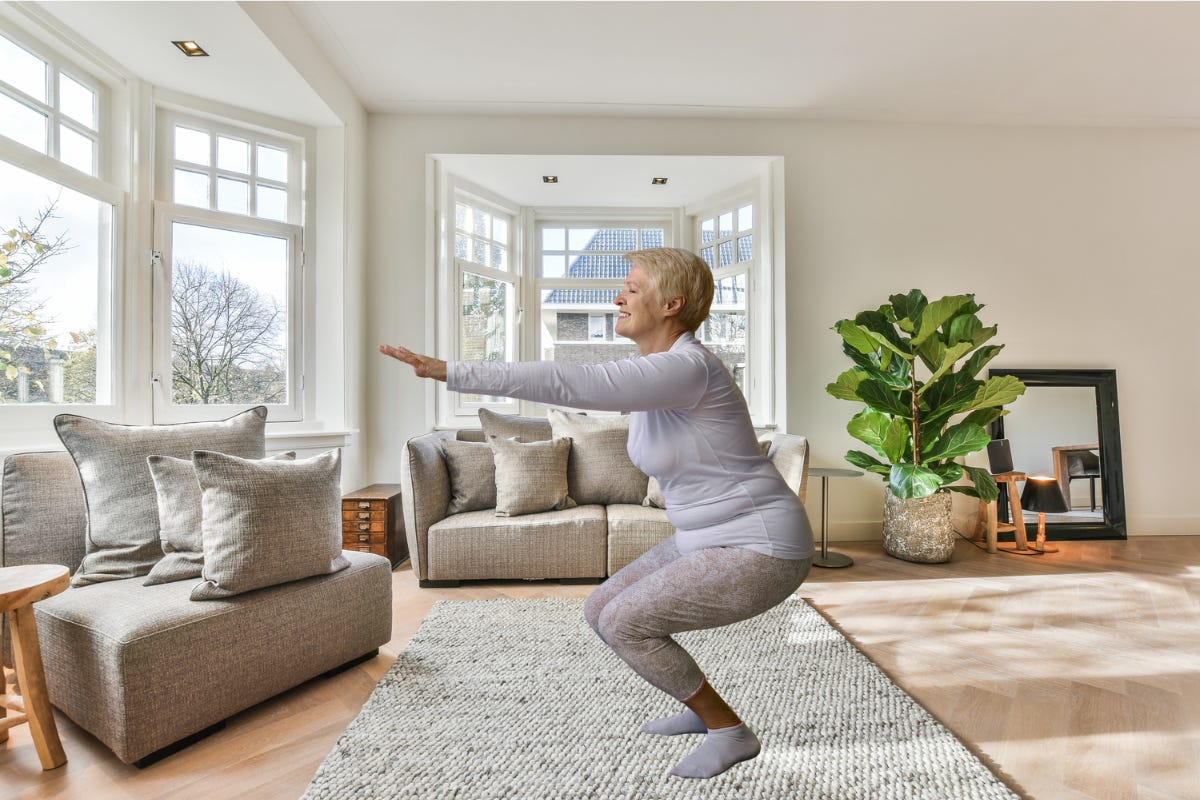 Older woman performing a squat exercise in a luxury lounge