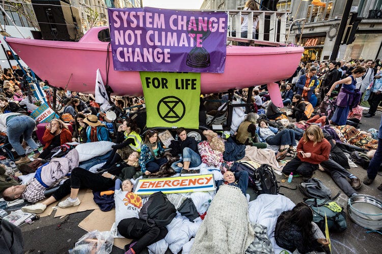 A pink boat in the middle of Oxford Circle surrounded by protestors and climate change banners. A pink boat in the middle of Oxford Circle surrounded by protestors and climate change banners.