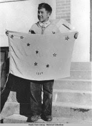 Benny Benson, an Alaska student, holds up the Alaska flag that he designed. His design was adopted as the official Alaska Flag. Benny Benson, an Alaska student, holds up the Alaska flag that he designed. His design was adopted as the official Alaska Flag.
