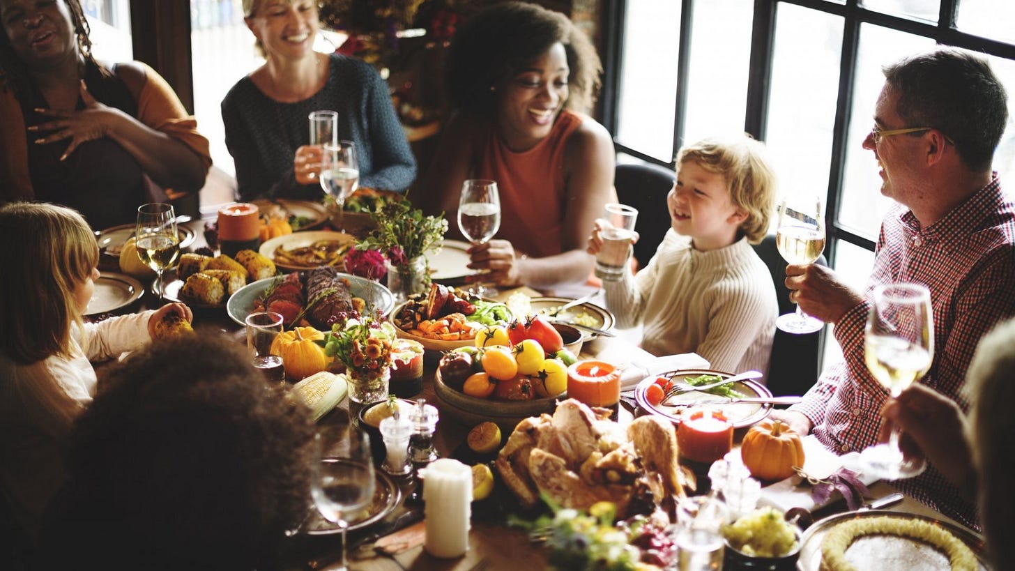 Diverse family and friends seated at a Thanksgiving table.