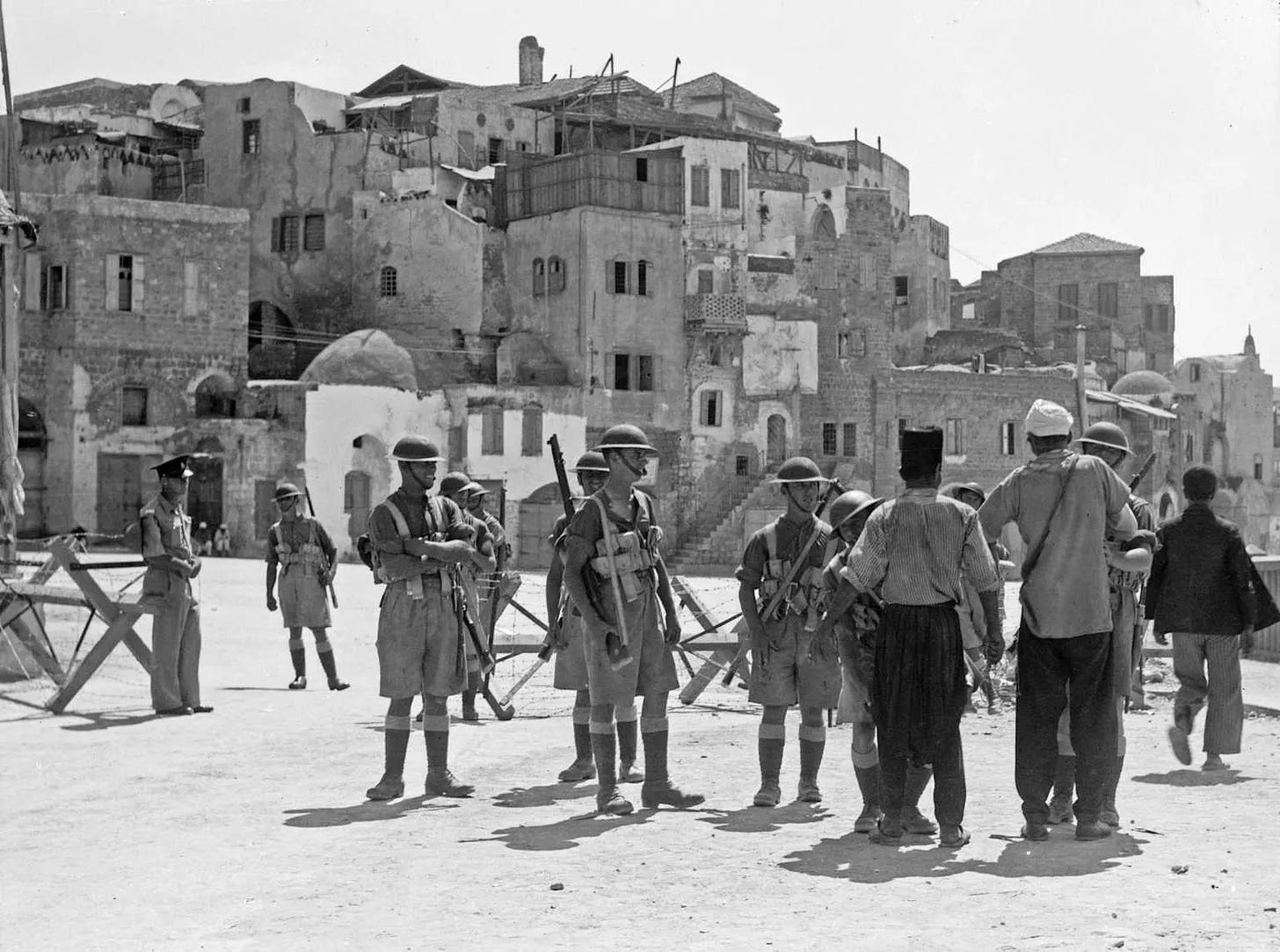 British soldiers searching Palestinian men for weapons in the port of Jaffa, during the Great Arab Revolt of 1936.