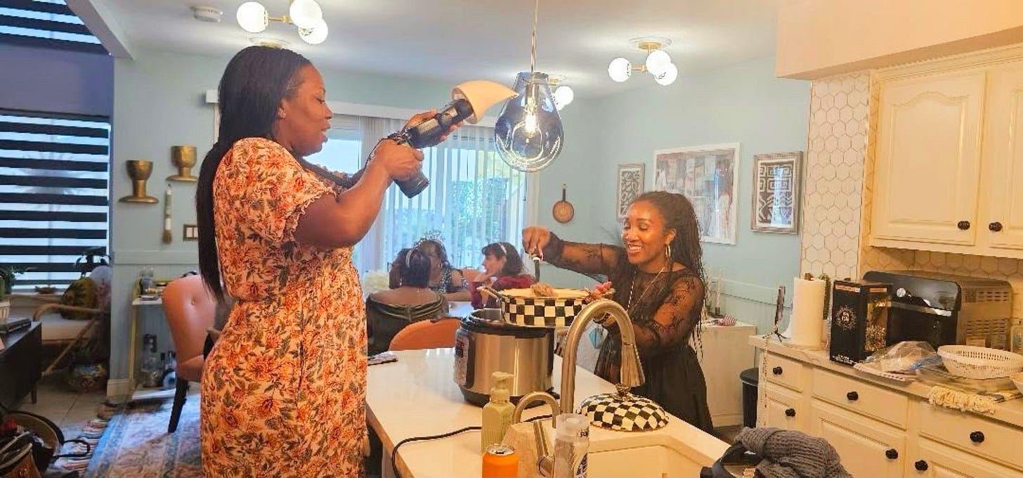 Black food creator Shaunda Necole with her photographer on set cooking in her home kitchen, capturing community, shared food traditions, and cultural connection through soul food