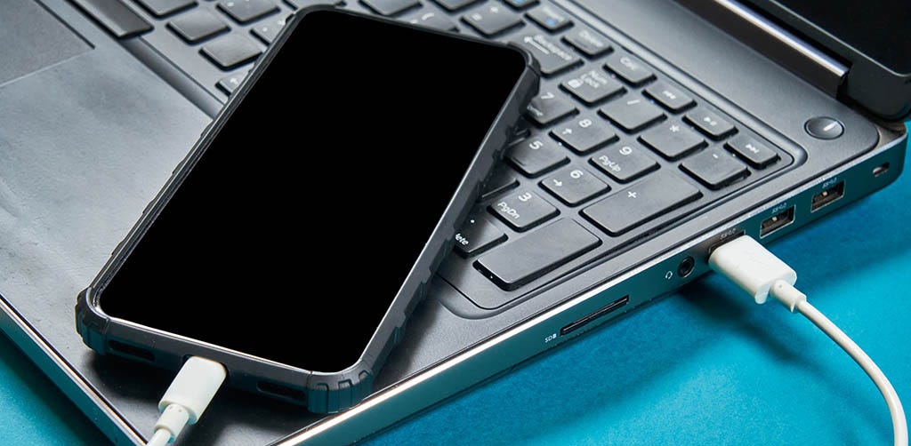 iPhone being charged by a laptop iPhone being charged by a laptop