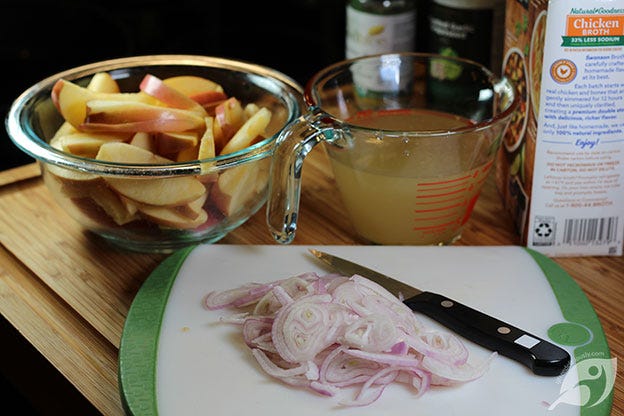 Sliced apples in a bowl, Sliced shallots on a cutting board, 1 cup chicken stock on a measuring cut Sliced apples in a bowl, Sliced shallots on a cutting board, 1 cup chicken stock on a measuring cut