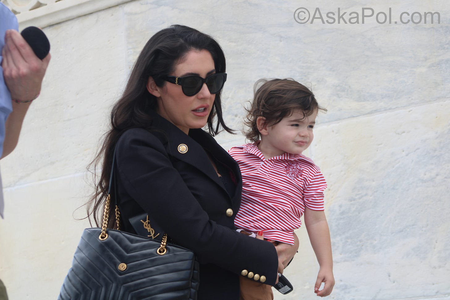 Woman in sunglasses carrying a baby walks Photo: Logan Johnson © Ask a Pol Woman in sunglasses carrying a baby walks Photo: Logan Johnson © Ask a Pol