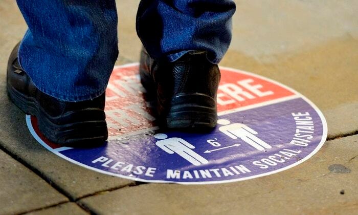 A voter stands on a social distance marker outside the Washington County Election Center in Hagerstown, Md., on  Oct. 26, 2020, for the first day of in-person early voting. (Colleen McGrath/The Herald-Mail via AP)