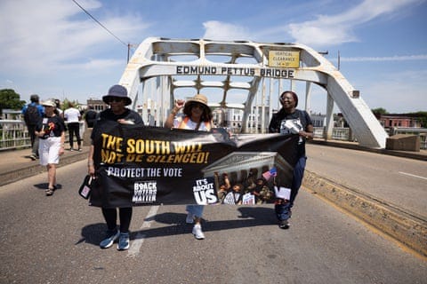 people hold a banner that reads 'the south will not be silenced' while walking across a bridge