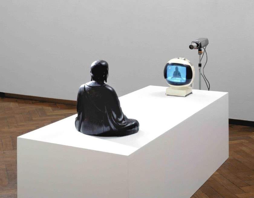 白南準《TV Buddha》裝置,佛像面向電視與攝影機|來源:Tate / Estate of Nam June Paik 白南準《TV Buddha》裝置,佛像面向電視與攝影機|來源:Tate / Estate of Nam June Paik