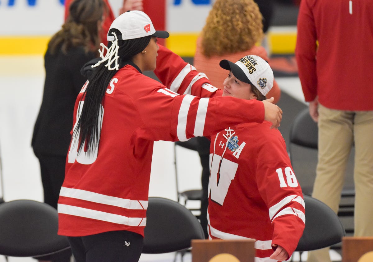 Laila Edwards and Marianne Picard wearing championship hats and their jerseys with pieces of the net from the title game cut out attached to the hat