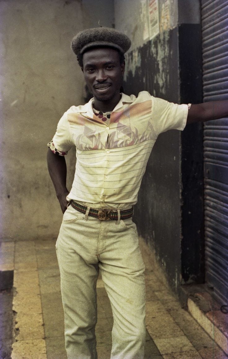 This may contain: a man is standing in an alley way with his arms out and wearing a hat