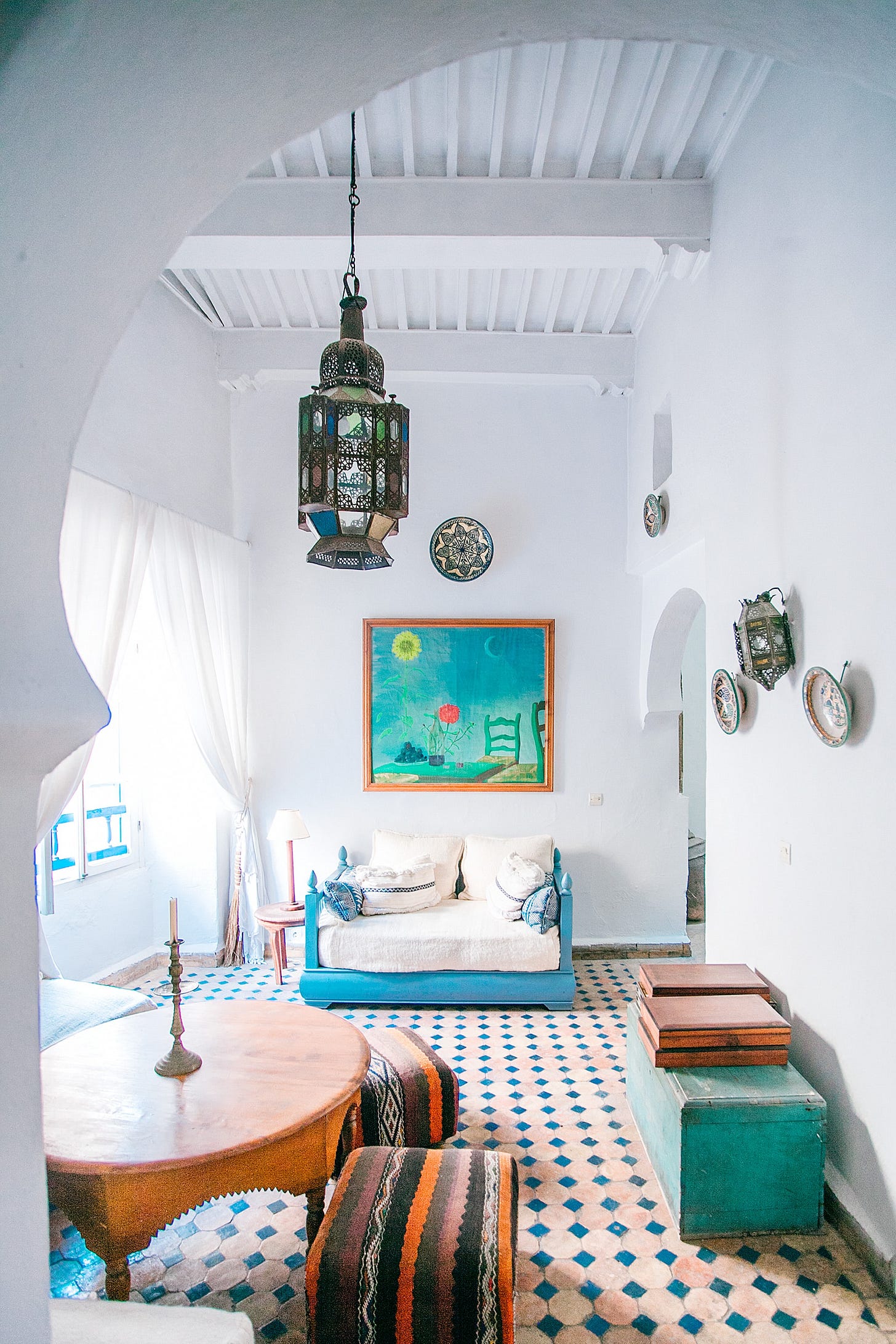 A room with prominent painting, a small table and seating A room with prominent painting, a small table and seating