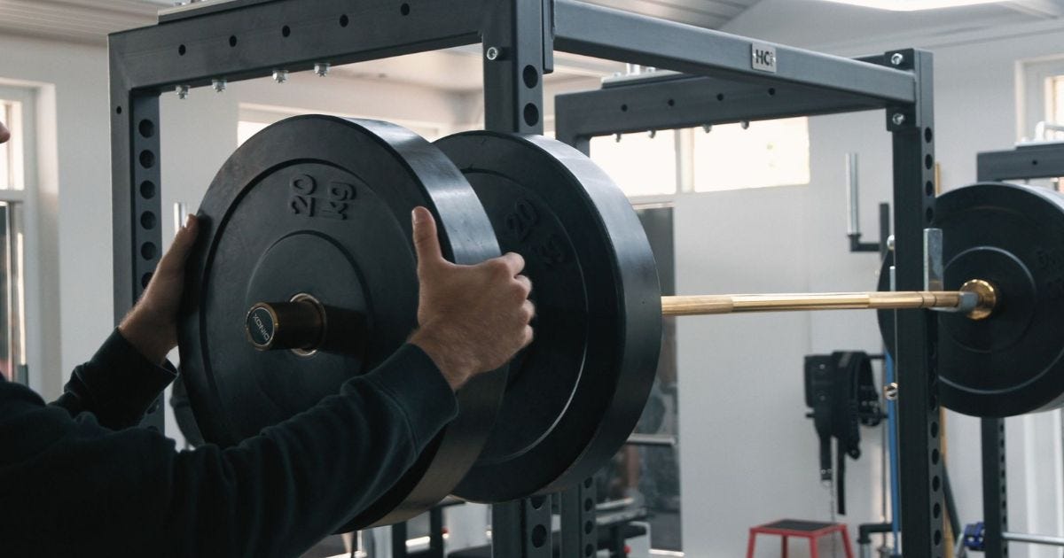 A person preparing a barbell for weightlifting in an indoor gym setting A person preparing a barbell for weightlifting in an indoor gym setting