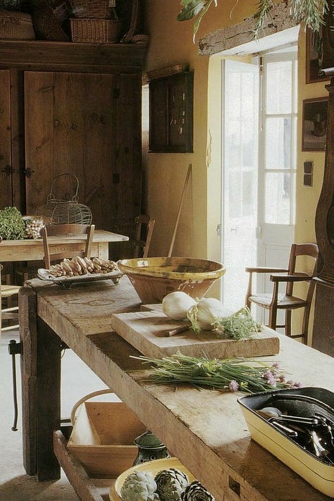 Italian style farmhouse kitchen. A cottage core window open with food on the bench. A loungeroom with leather chairs and a fireplace and library.