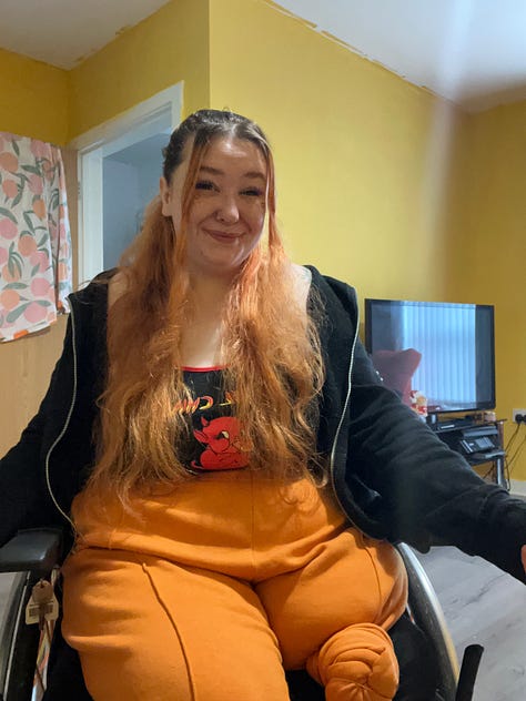 Image 1: Becca sitting in her wheelchair smiling warmly at the camera in a bright yellow room, wearing an orange outfit and black hoodie. The photo captures a relaxed moment at home before beginning her mentoring journey.  Image 2: Screenshot of an email confirming Becca’s one-to-one meeting with MCR Pathways on 18 September 2023, outlining the next steps for her mentor registration and ID verification.  Image 3: Screenshot of Becca’s MCR Pathways mentor training reminder email for 12 October 2023, showing colourful illustrated icons of the mentoring process from registration to meeting a young person.