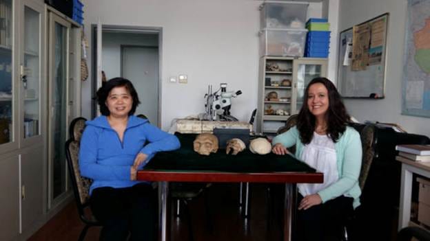 Two women sitting at a table with skulls on it

AI-generated content may be incorrect.