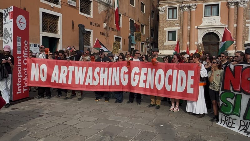Protestors at the Venice Biennale with a banner reading "no artwashing genocide" Protestors at the Venice Biennale with a banner reading "no artwashing genocide"