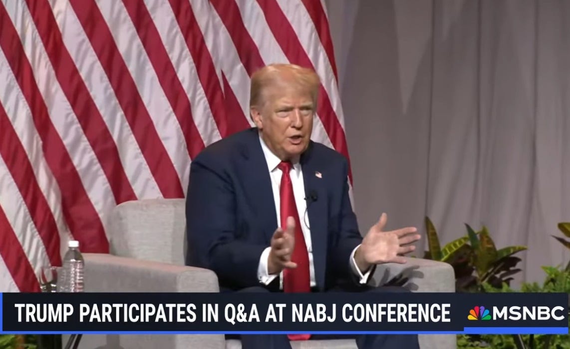 Donald Trump sits in an armchair in front of a big US flag during an interview, gesturing like he's playing an accordion. Donald Trump sits in an armchair in front of a big US flag during an interview, gesturing like he's playing an accordion.