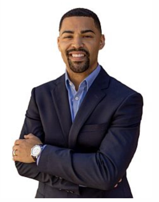 A person in a suit with his arms crossed

Description automatically generated