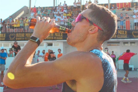 a man drinks a beer during a race