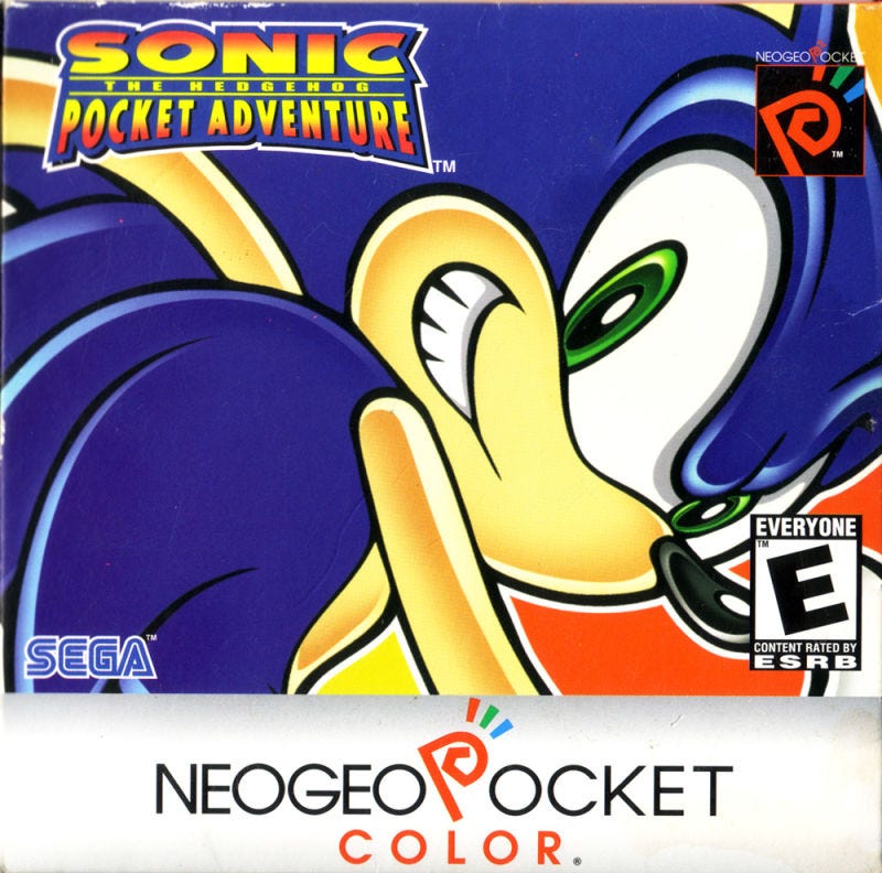 An image of the box art for Sonic the Hedgehog Pocket Adventure, featuring a very zoomed in rendering of a grinning Sonic, as well as the system's and Sega's logos