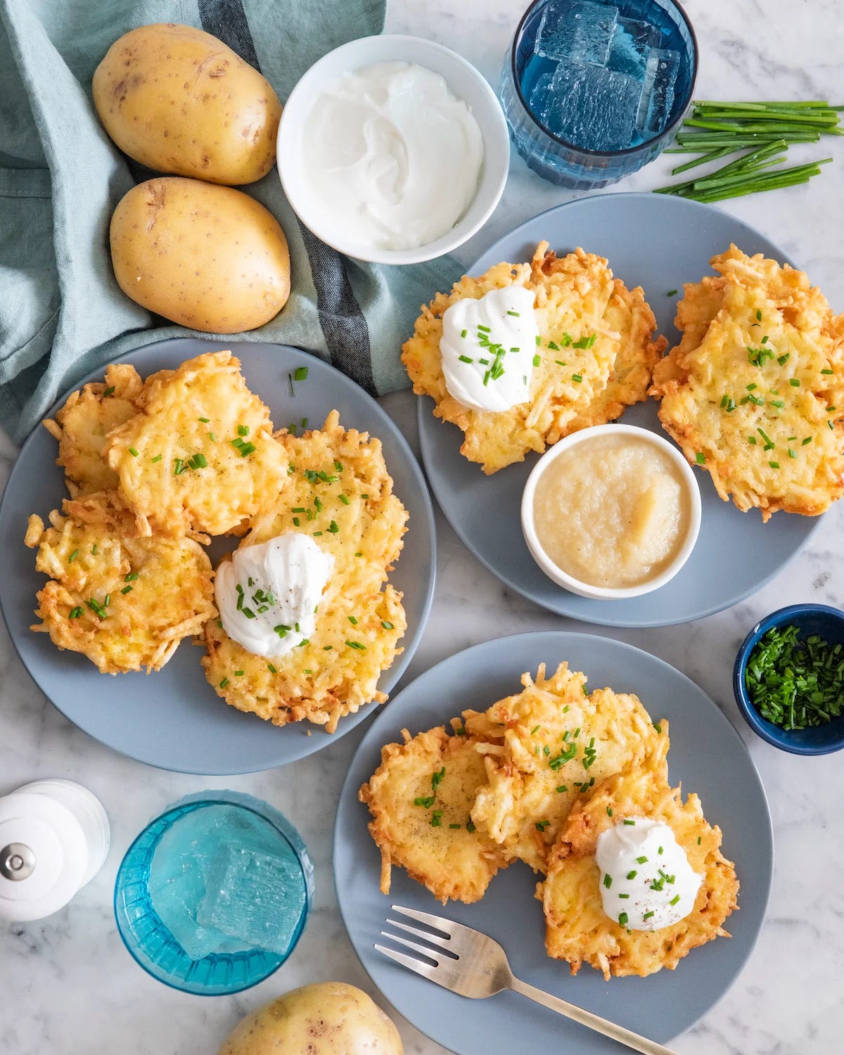  Latkes on light blue plates and containers of toppings