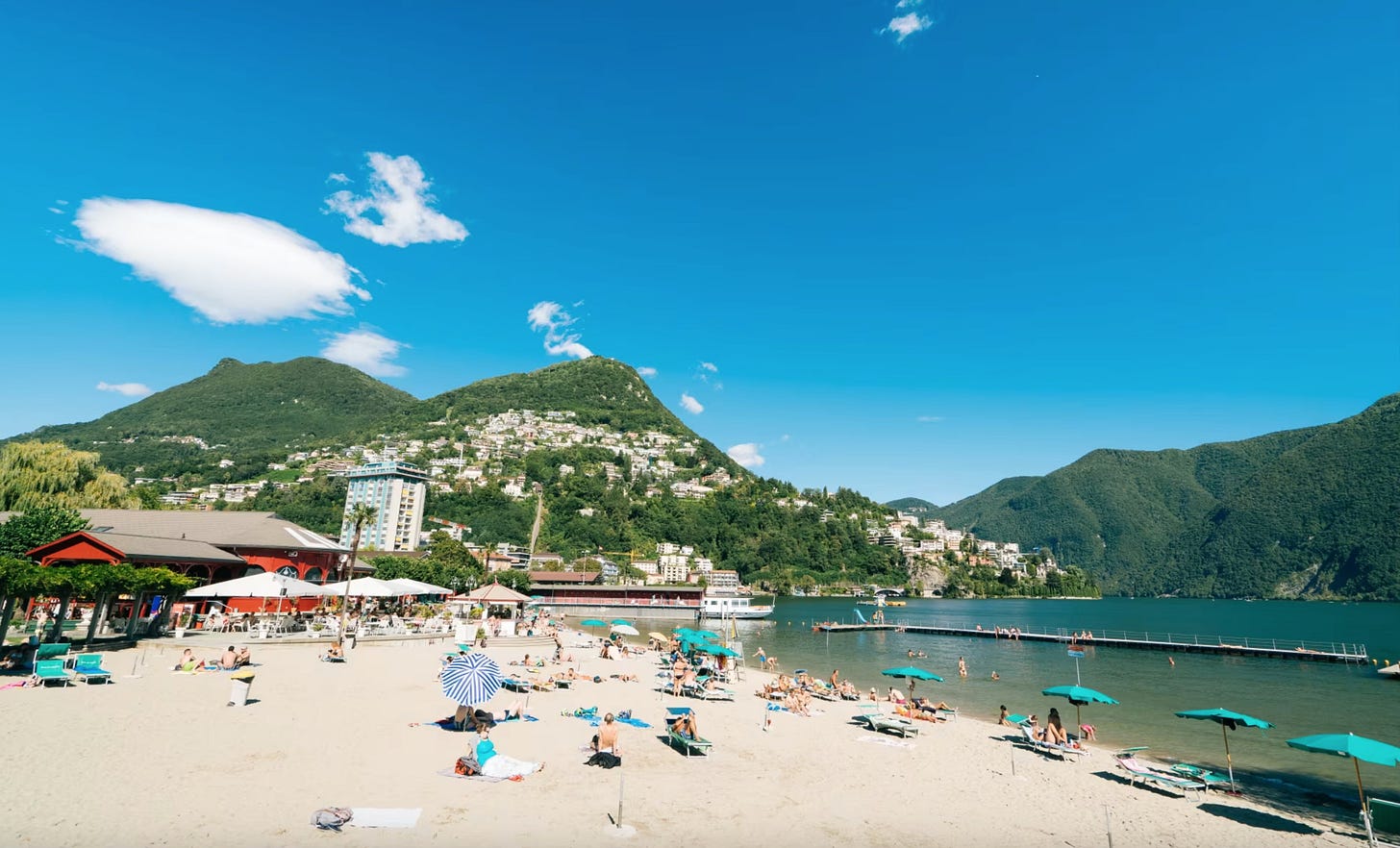 The sandy beach of Lido di Lugano, with a mountainous backdrop.