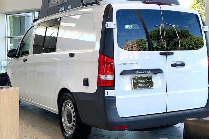 Mercedes-Benz Metris Camper Van with pop top open in the dealership showroom.