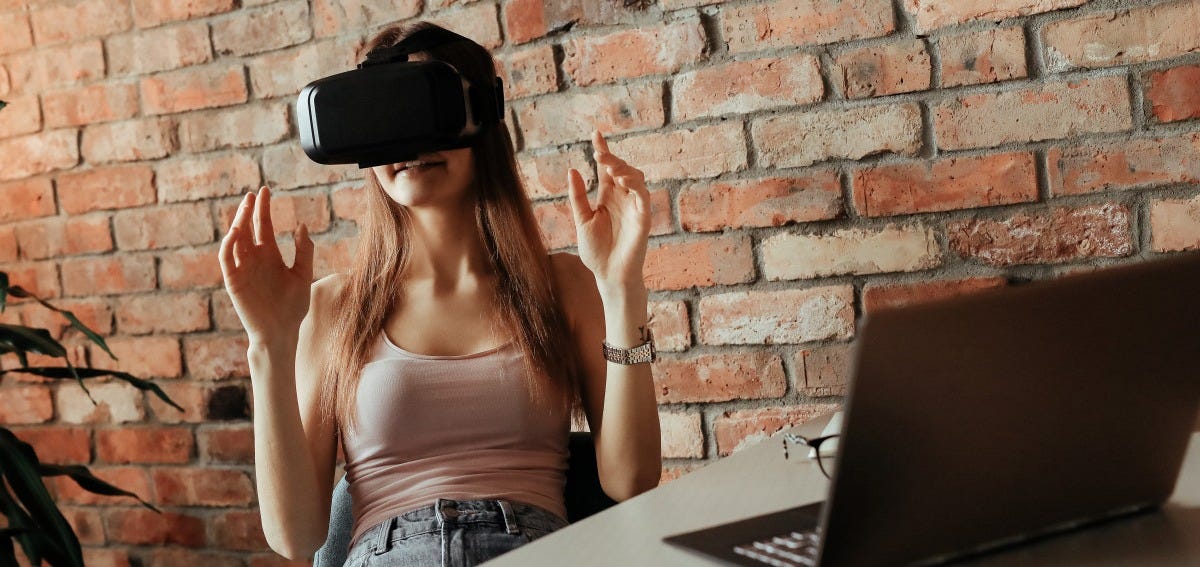 3d, vr headset, simulation, simulator, tech, technology, video, viral, visual, vr, beautiful, beauty, cyber, device, digital, face, female, fun, future, futuristic, gamer, gaming, girl, glasses, goggles, hair, hairstyle, happiness, happy, headset, home, innovation, joy, leisure, looking, modern, reality, shirt, watching, wearable, wearing, woman, young, brick wall, space, table, laptop, computer, wall, sitting, hat, leg, shoulder, headgear, brick, photography, sun hat, muscle, electronic device, photo shoot, fashion accessory, brickwork, brown hair, fedora, model