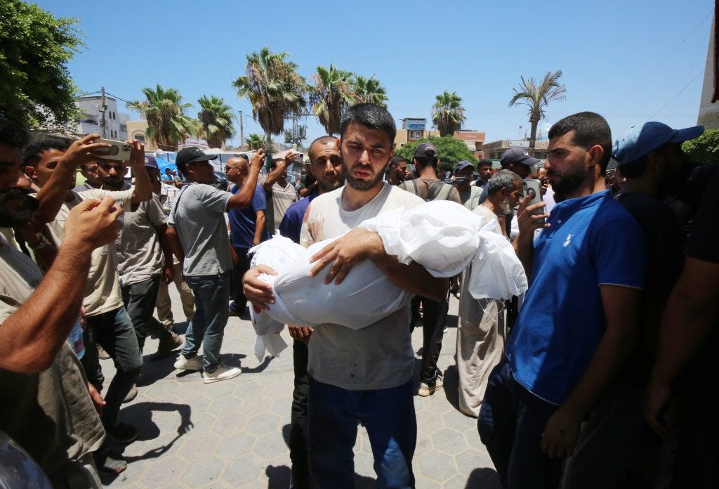 Relatives of Palestinians killed in Israeli airstrikes at Al-Aqsa Hospital in Deir al-Balah prepare their loved ones for burial, July 9, 2024. (Photo: Ali Hamad/APA Images)